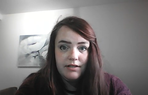 an screenshot of Amy, the video creator, talking to camera. She is sitting down in a room with a wall behind her.